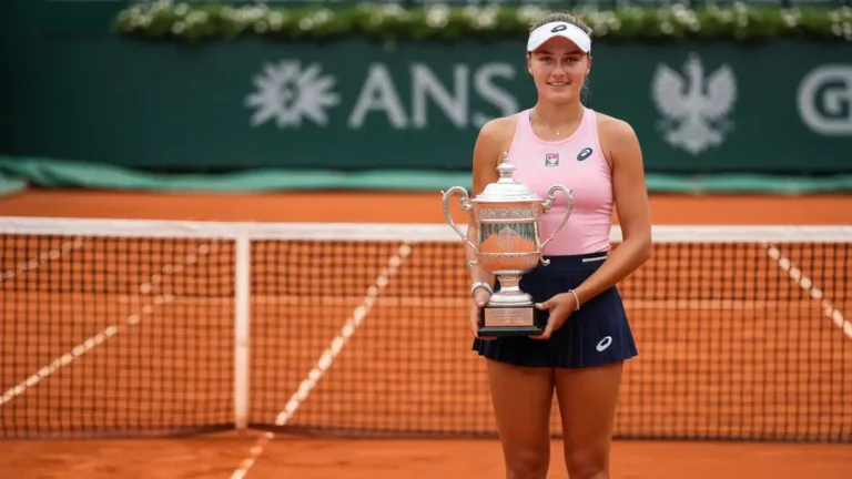 Iga Świątek w stroju tenisowym, portret 3:4 na korcie Roland Garros z trofeum