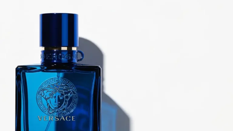 Versace Eros flakon perfum męskich z charakterystycznym niebieskim kolorem i logo Versace na białym tle z delikatnymi refleksami światła